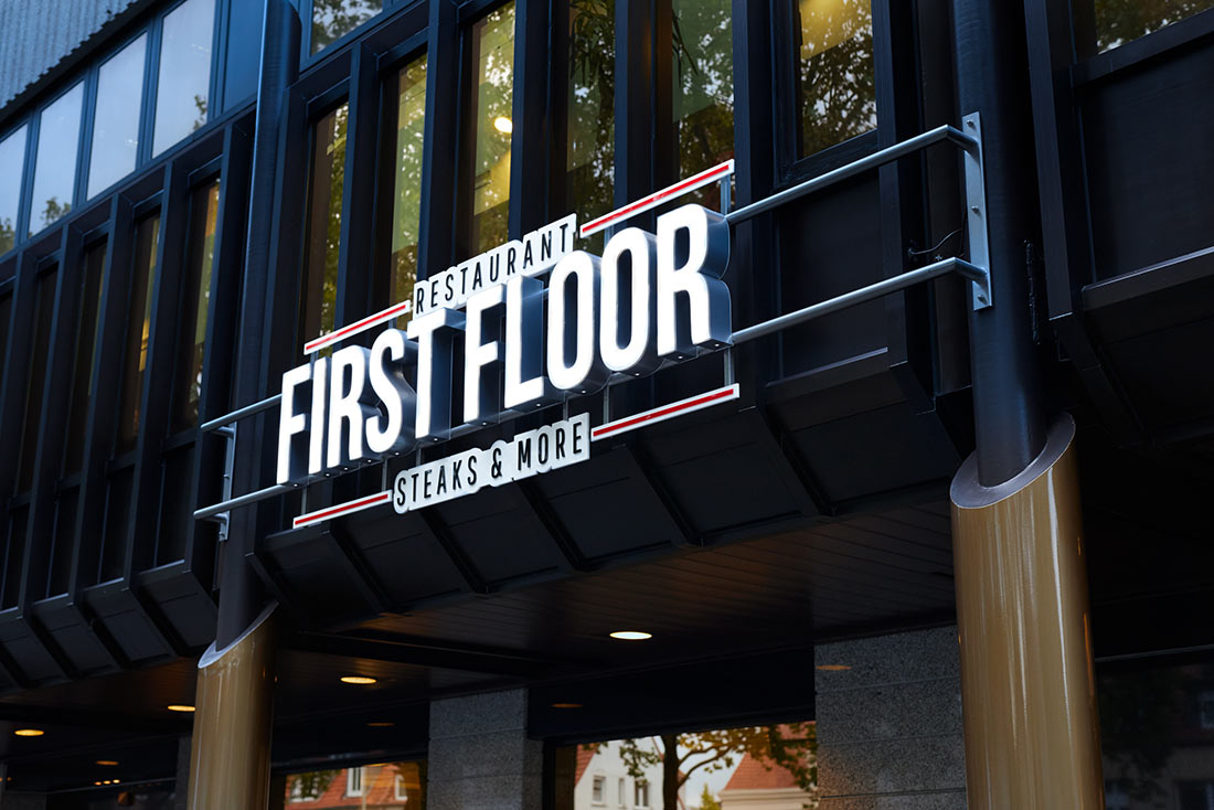 Nahaufnahme des Leuchtschilds an der Fassade des First Floor