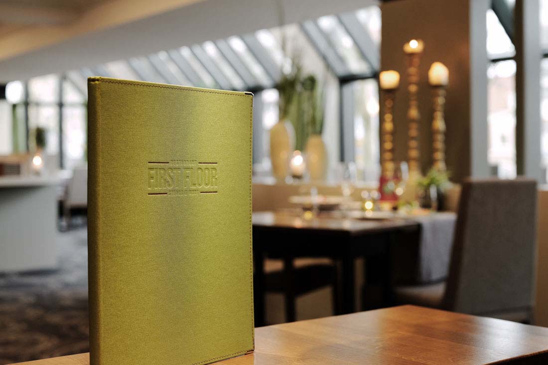 Speisekarte im Vordergrund, Restaurant im Hintergrund